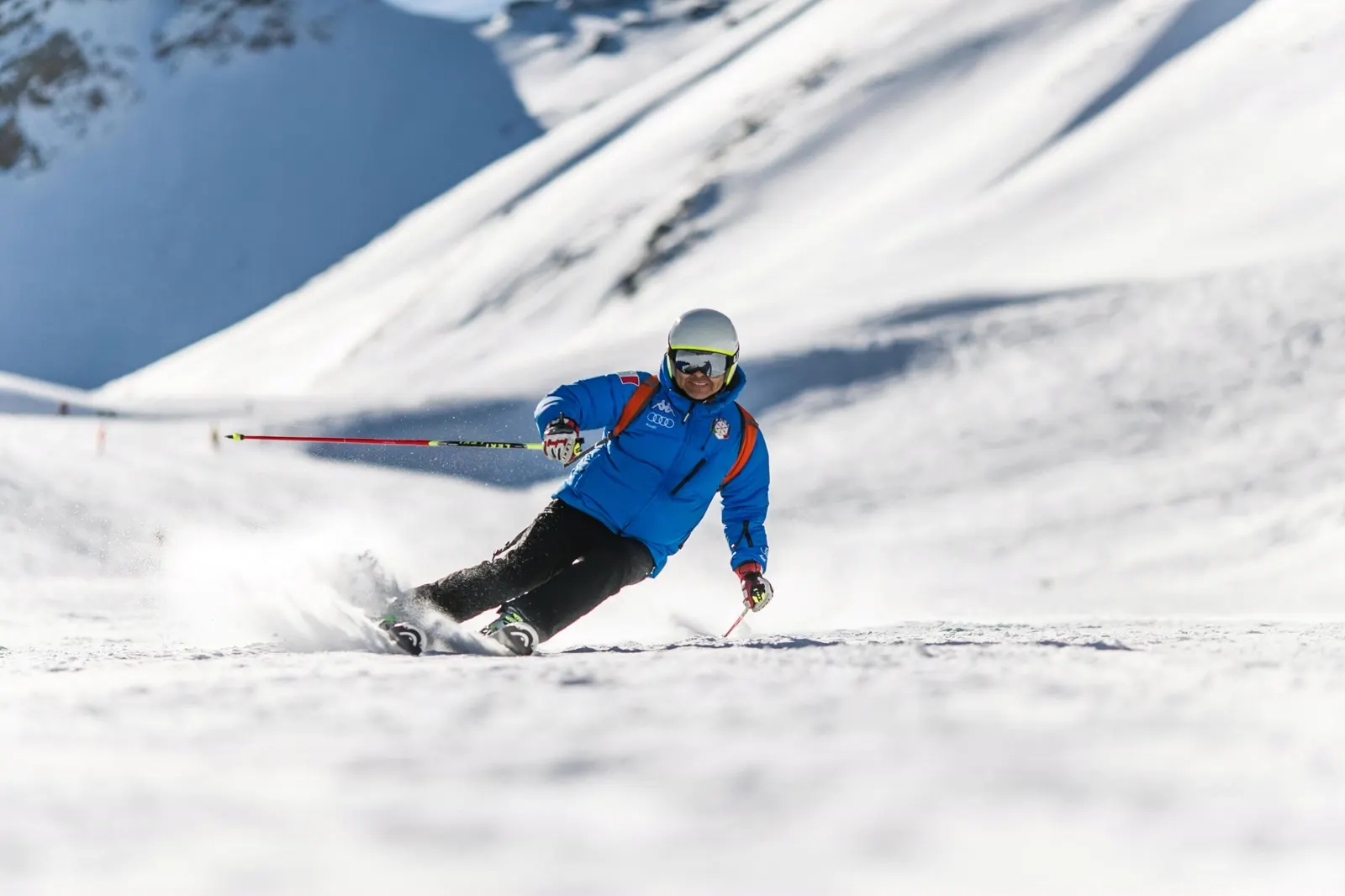 Skier descending a prepared alpine slope